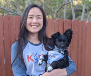 Aileen and her dog pose for a photo with matching KIF1A.ORG tops